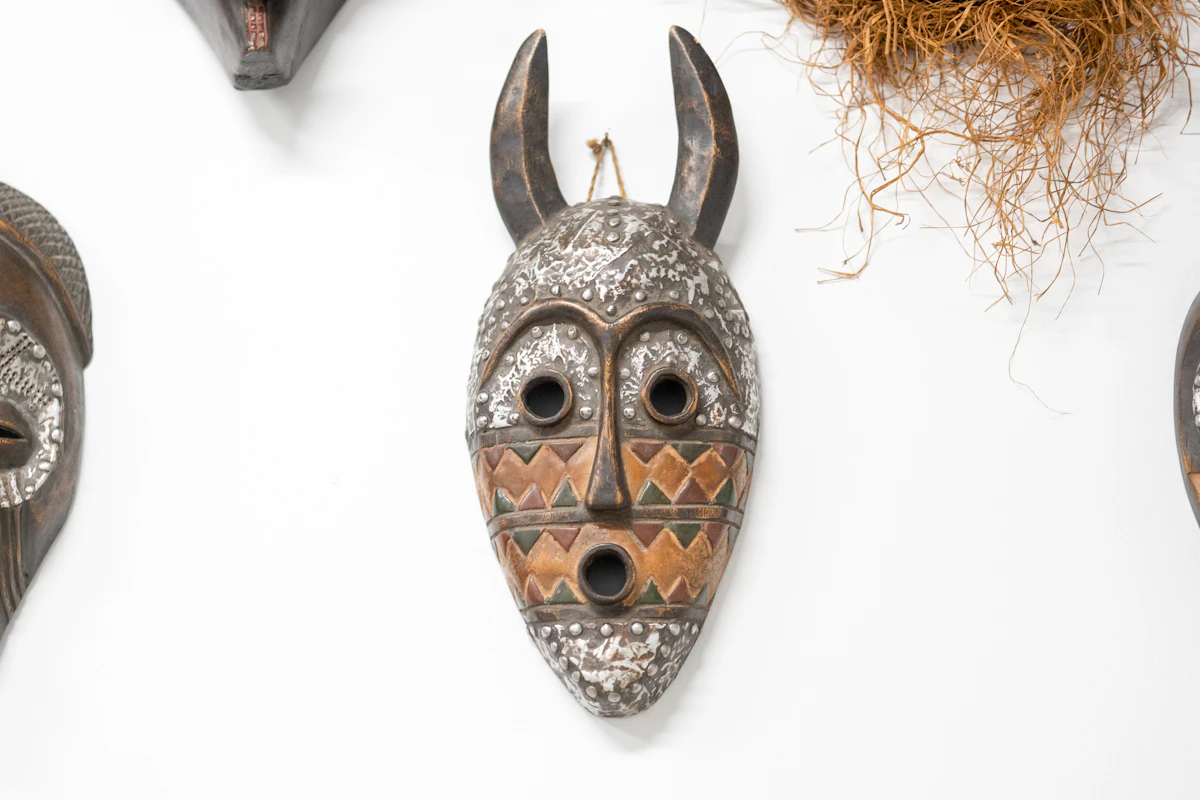 A wall display of several carved masks arranged together