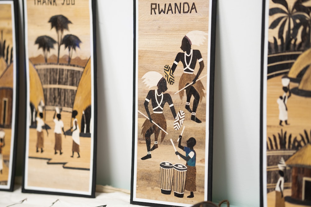 a row of framed african art hanging on a wall