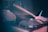 A close-up of hands playing a drum set in a cozy classroom.