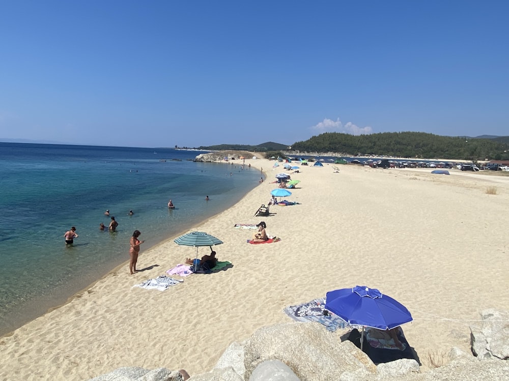 a beach filled with lots of people and umbrellas