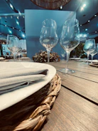 A refined detail shot of elegant glassware and cutlery arranged with precision on a dark linen tablecloth.