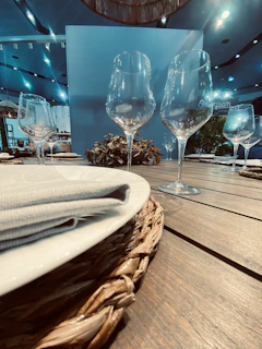 Close-up of a crystal wine glass catching soft light beside an elegant ivory tablecloth at an acclaimed restaurant