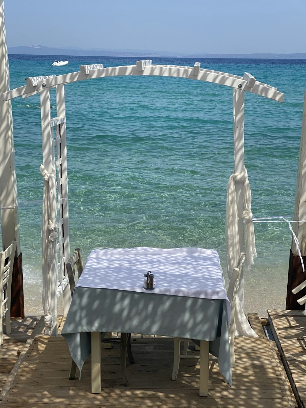 a table and chairs on a beach near the ocean
