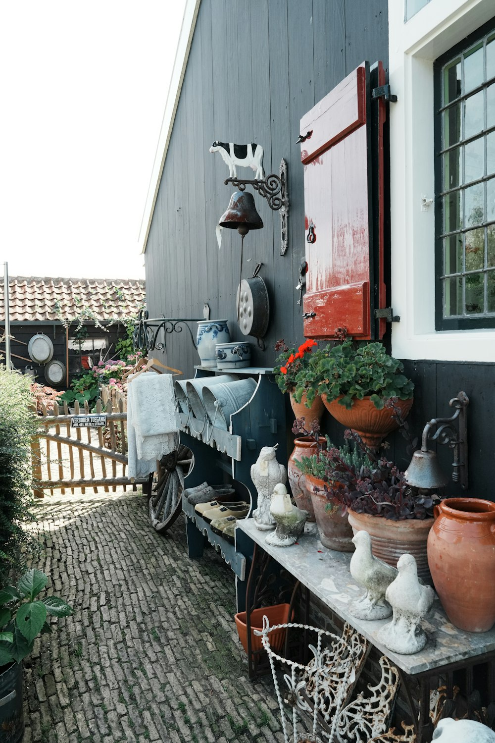 a house with a bunch of potted plants on the outside of it