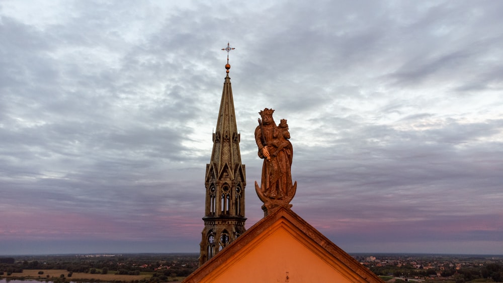 a church steeple with a statue on top of it