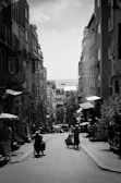 A black and white photo of city streets bustling with life.