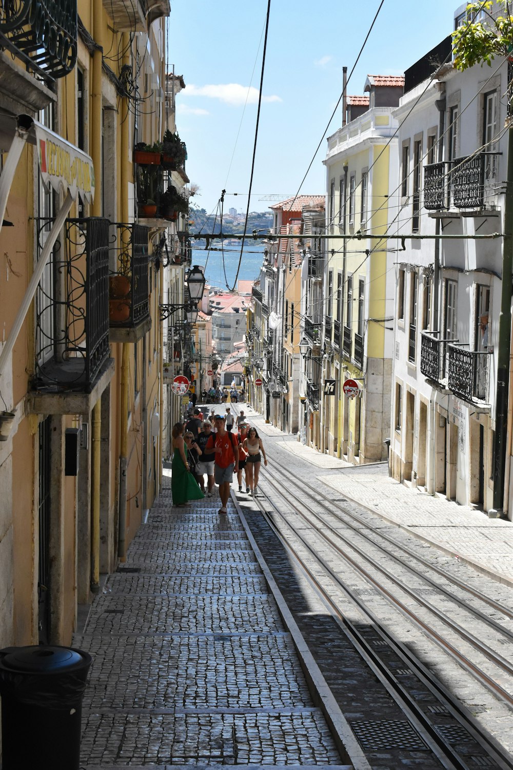 a group of people walking down a street next to tall buildings