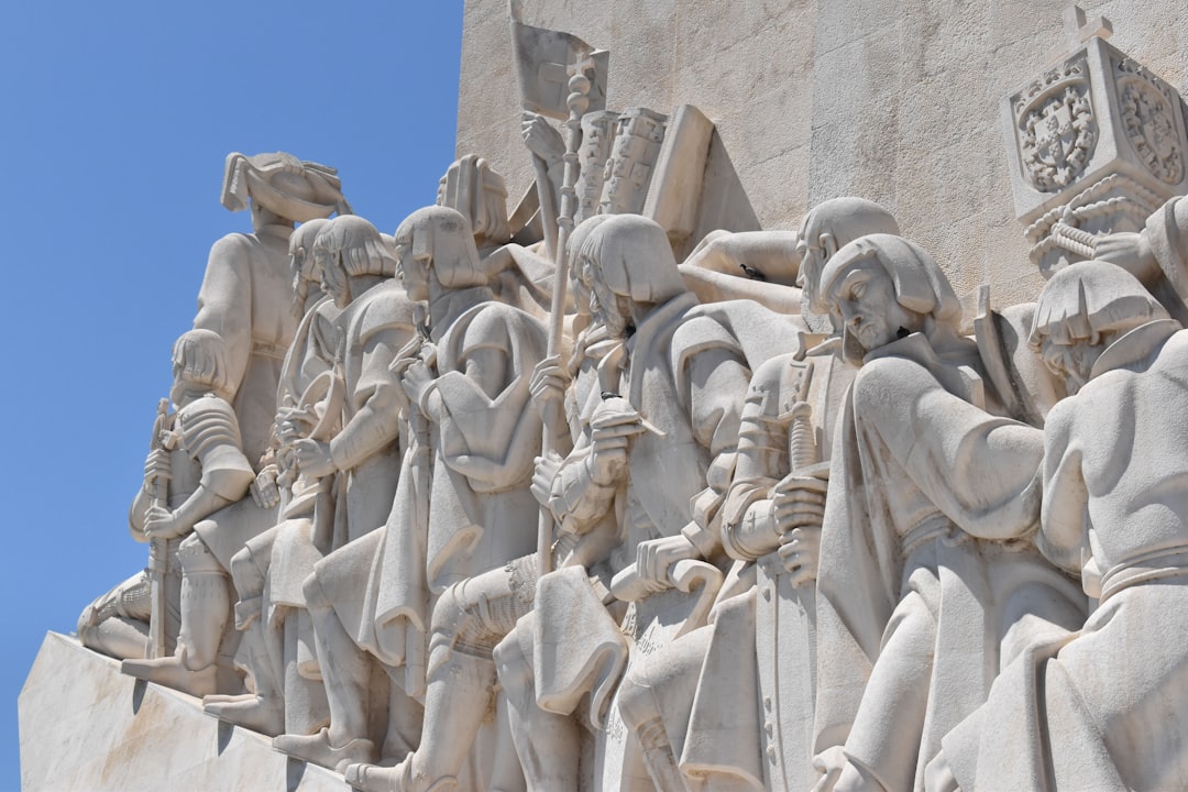 a group of statues on a wall with a blue sky in the background