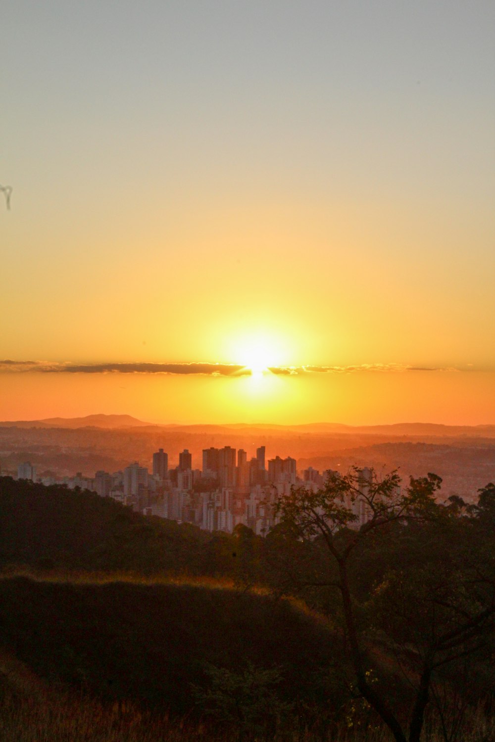 the sun is setting over a city in the distance