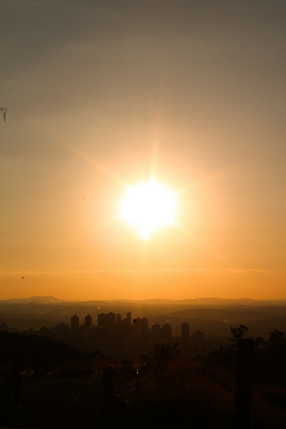 the sun is setting over a city in the distance