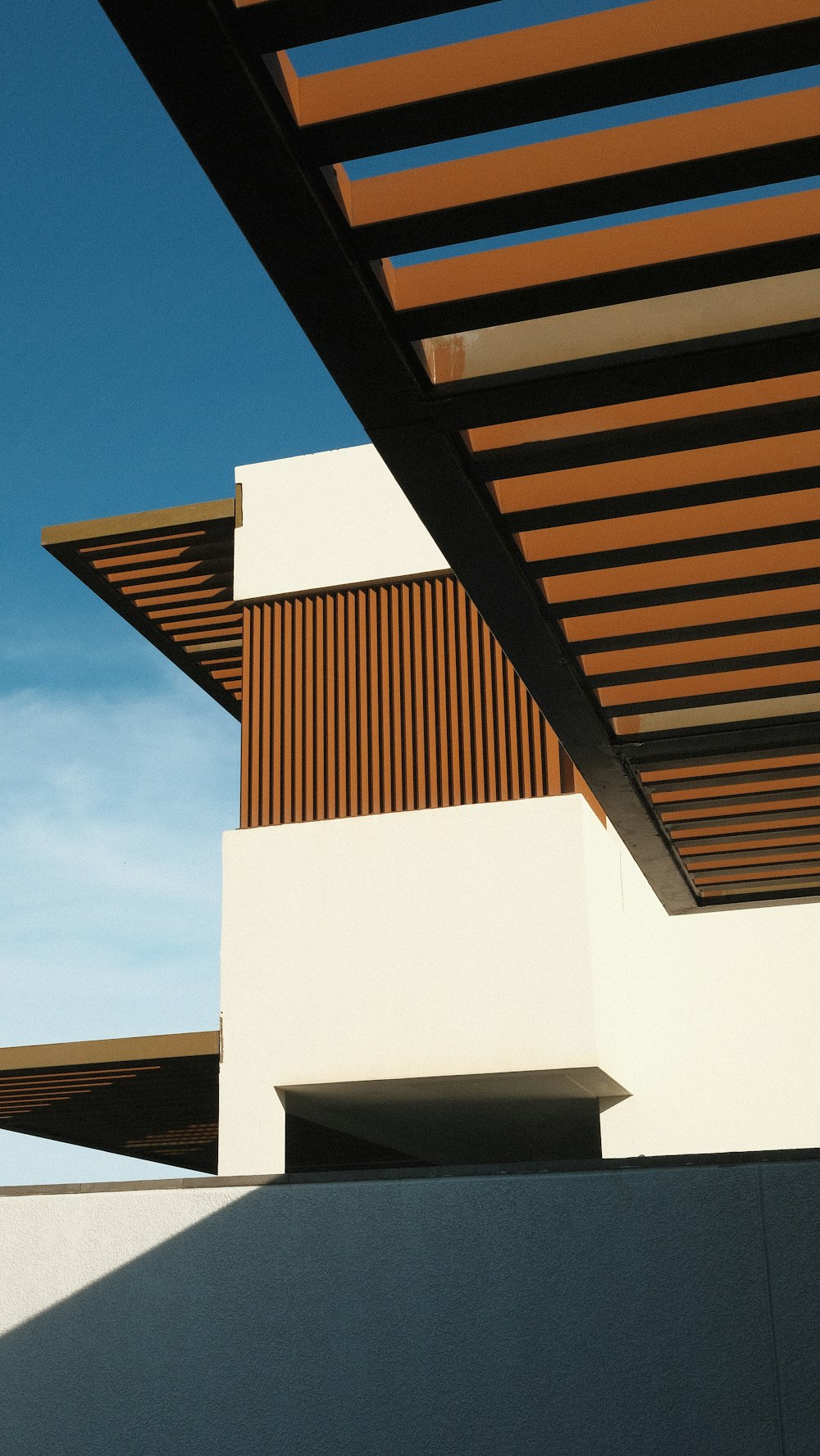 a white building with a wooden roof and a sky background