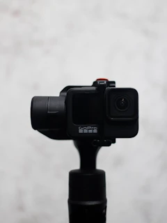 Sleek 360 camera resting on a minimalist white surface with soft shadows.