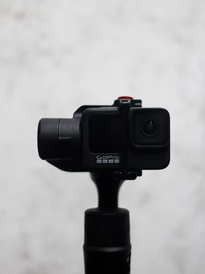Sleek 360 camera resting on a minimalist white surface with soft shadows.