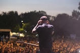 a man standing in front of a crowd holding a guitar