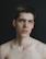 Sophisticated profile photo of a man with a gentle smile against a neutral background.