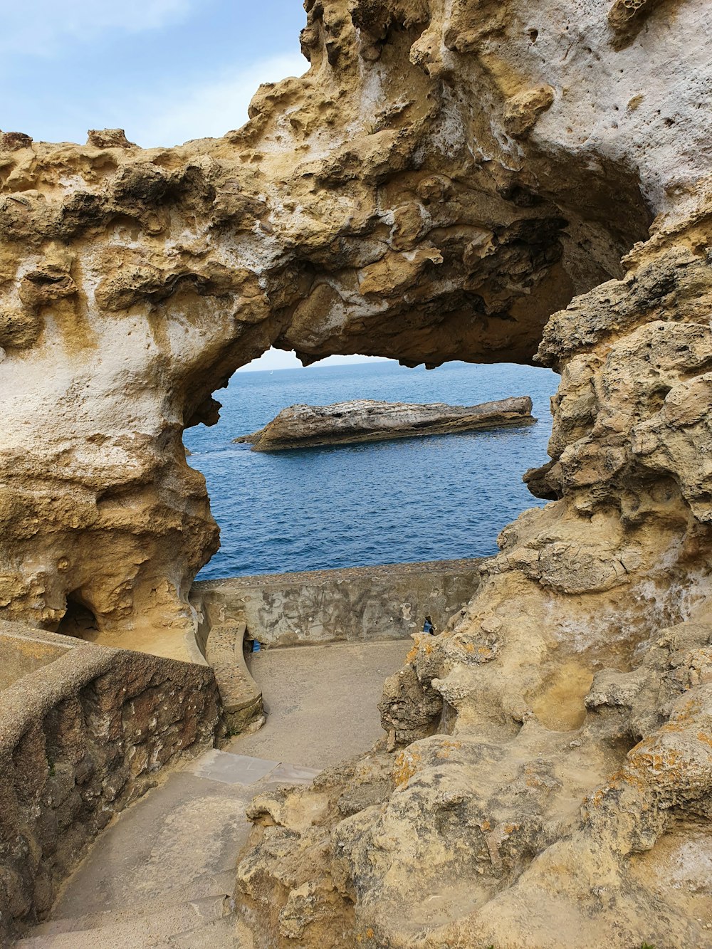 a large rock formation with a small boat in the water