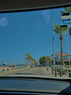 A taxi cruising along a coastal road with Marari Beach visible on the side, sunlight sparkling on the water.