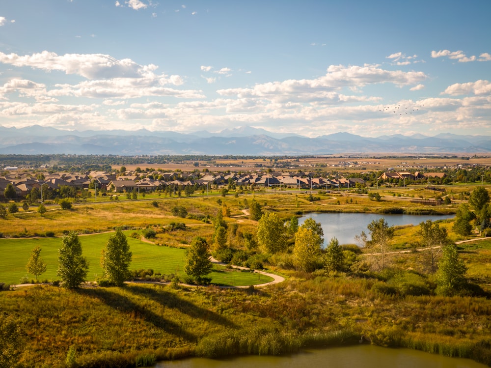 Una vista panorámica de un campo de golf con un lago en primer plano