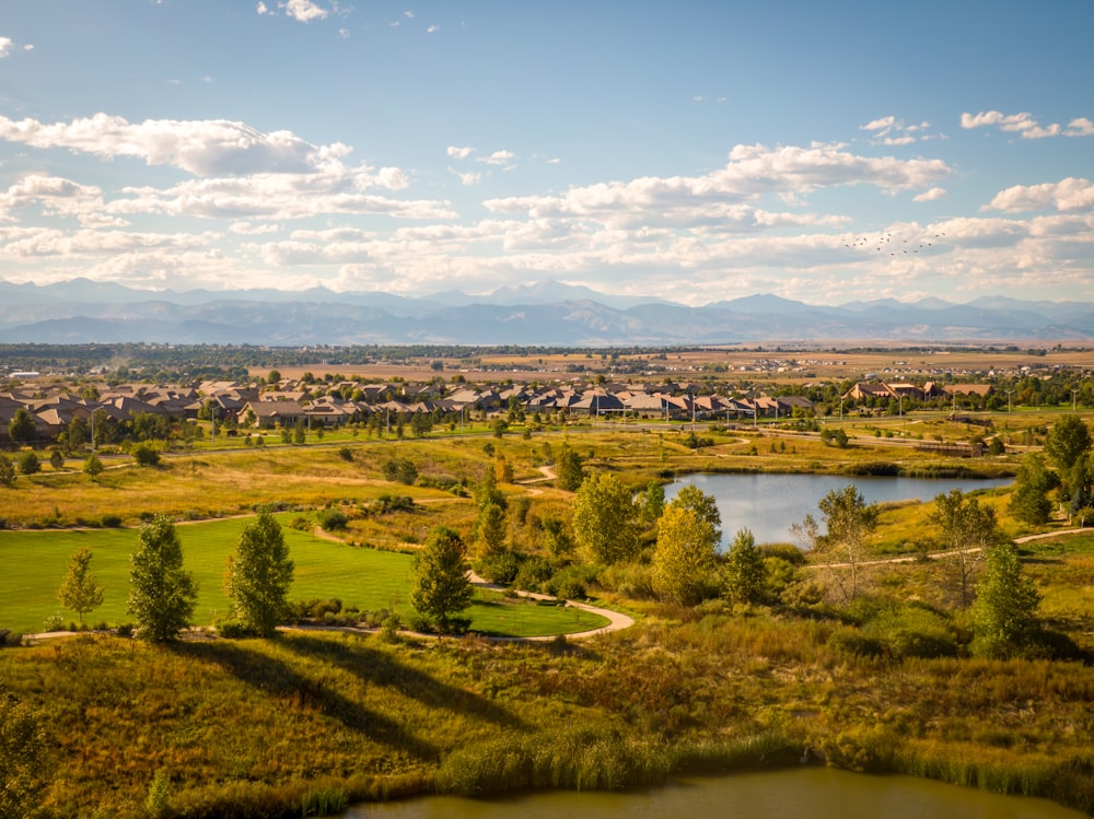 a scenic view of a golf course with a lake in the foreground
