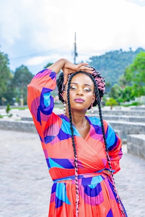 A cheerful woman dressed in colorful fashion standing outdoors.