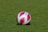 a soccer ball sitting on top of a lush green field