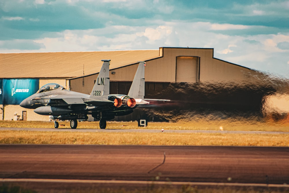 a fighter jet sitting on top of an airport runway