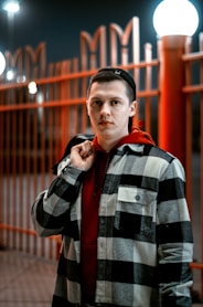 a man standing in front of a fence