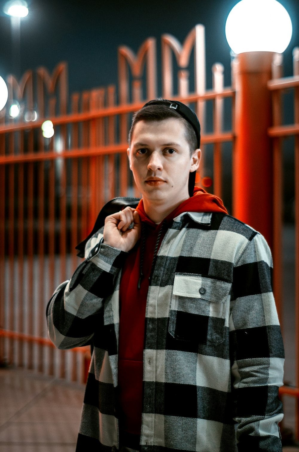 a man standing in front of a fence