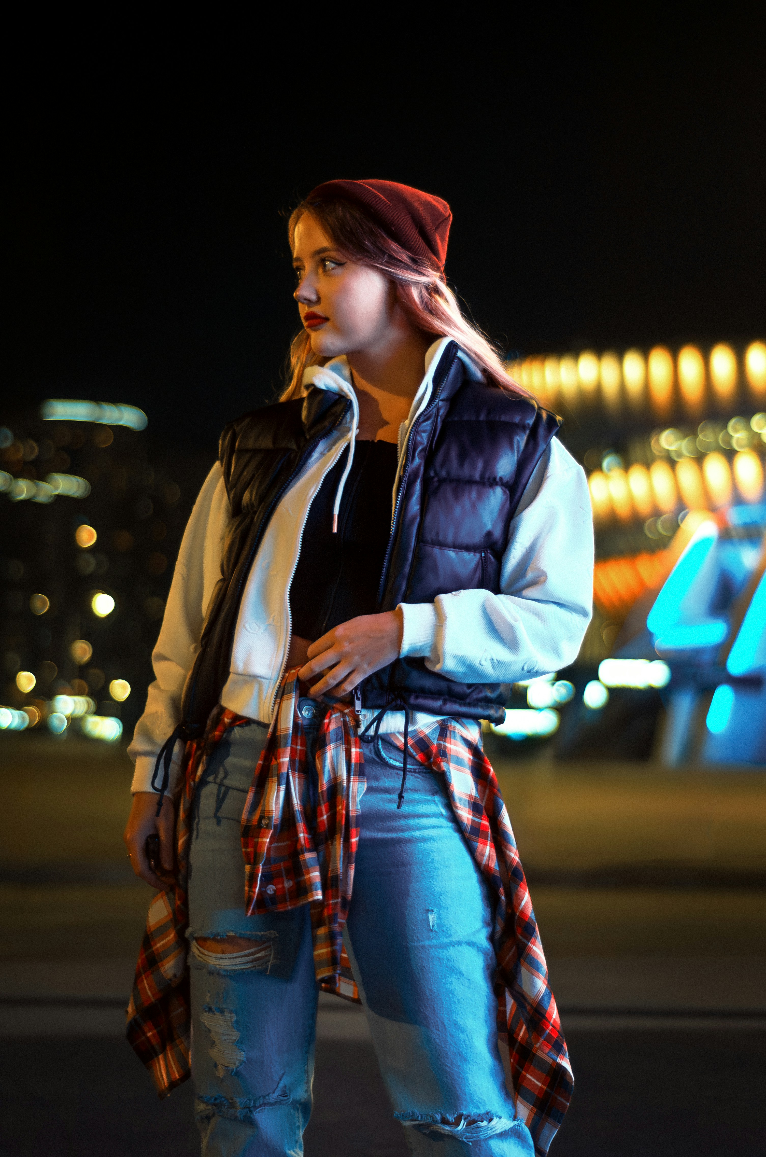 a woman standing in front of a building at night
