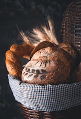 Traditional German breads and pretzels styled on a white cloth with a dark background.