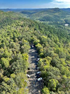 Wide shot of a freshly paved parking lot surrounded by lush Maine trees.