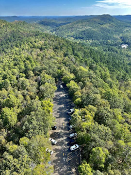 Wide shot of a freshly paved parking lot surrounded by lush Maine trees.