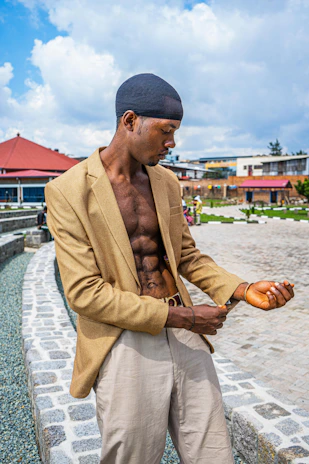 Close-up of a man adjusting his khawani & co jacket outdoors on a sunny day.