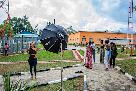 African woman confidently leading a community workshop, natural light, documentary style.