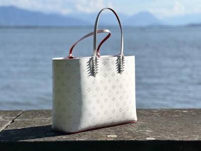 a white purse sitting on top of a wooden table