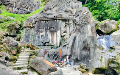 a statue of a face in the middle of some rocks