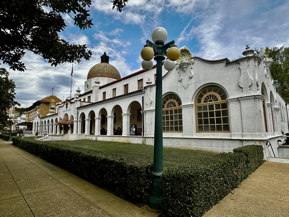 a white building with a green lamp post in front of it