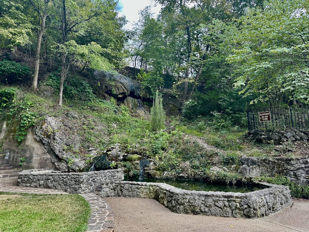 a stone bench sitting on top of a lush green hillside