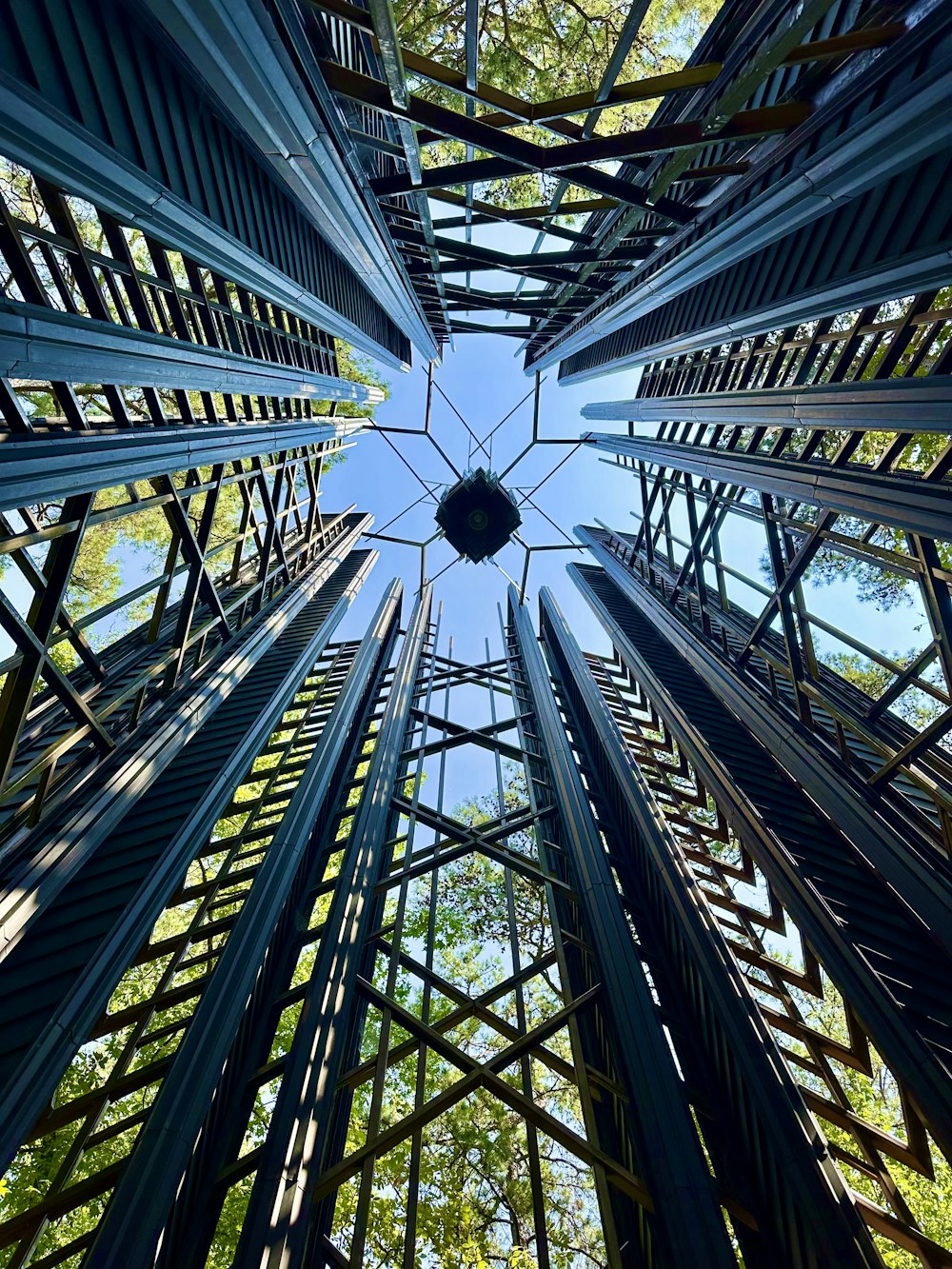 looking up at a metal structure with trees in the background