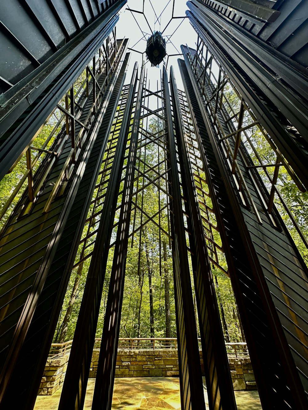 olhando para cima para uma estrutura metálica em uma floresta