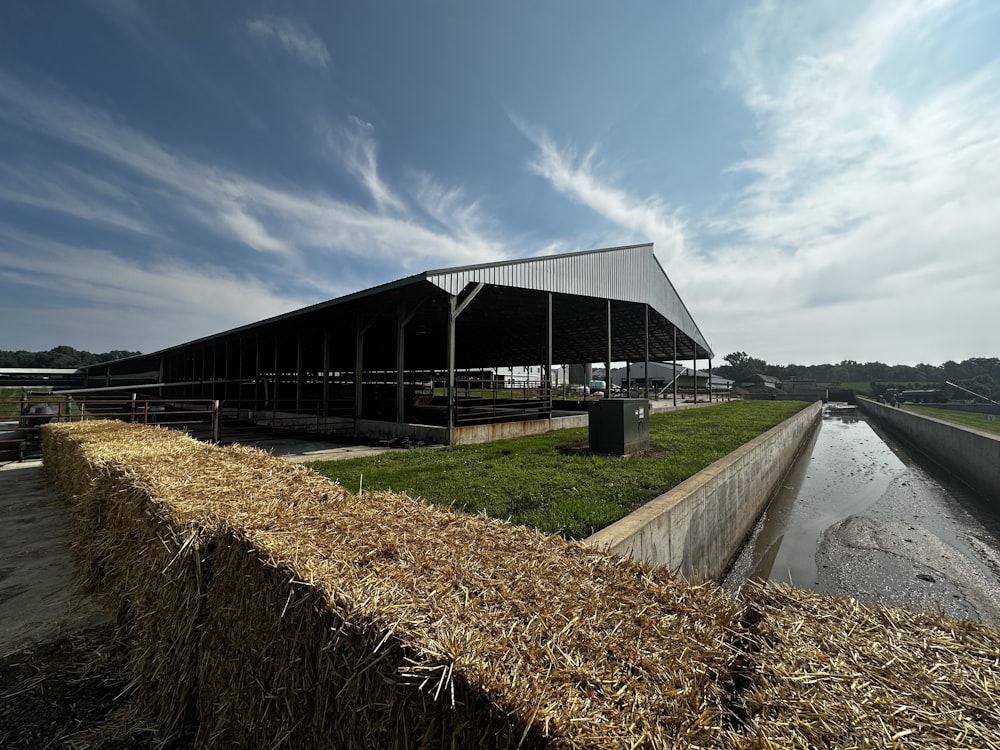 a large building with a roof next to a body of water