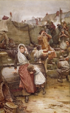 A group of people appears to be gathered near a seawall in a coastal village, possibly awaiting or seeing off a ship. The central figure is a woman with a shawl over her head, sitting on a barrel and holding a young child who clings to her. Other people around include men and women, some wearing hats, looking towards the sea with anxious or concerned expressions. The background features residential buildings and cloudy skies, suggesting a somber or tense atmosphere.