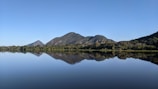 A serene landscape with a tranquil lake reflecting mountains.