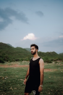 A confident man standing outdoors with a serene expression
