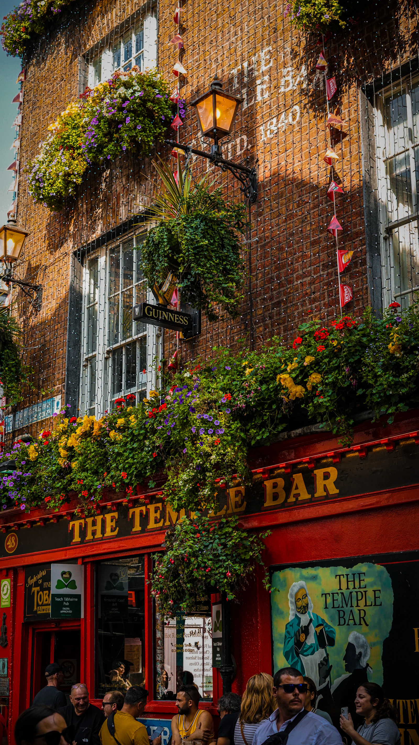 The red Temple Bar pub in Dublin with flower baskets and lanterns