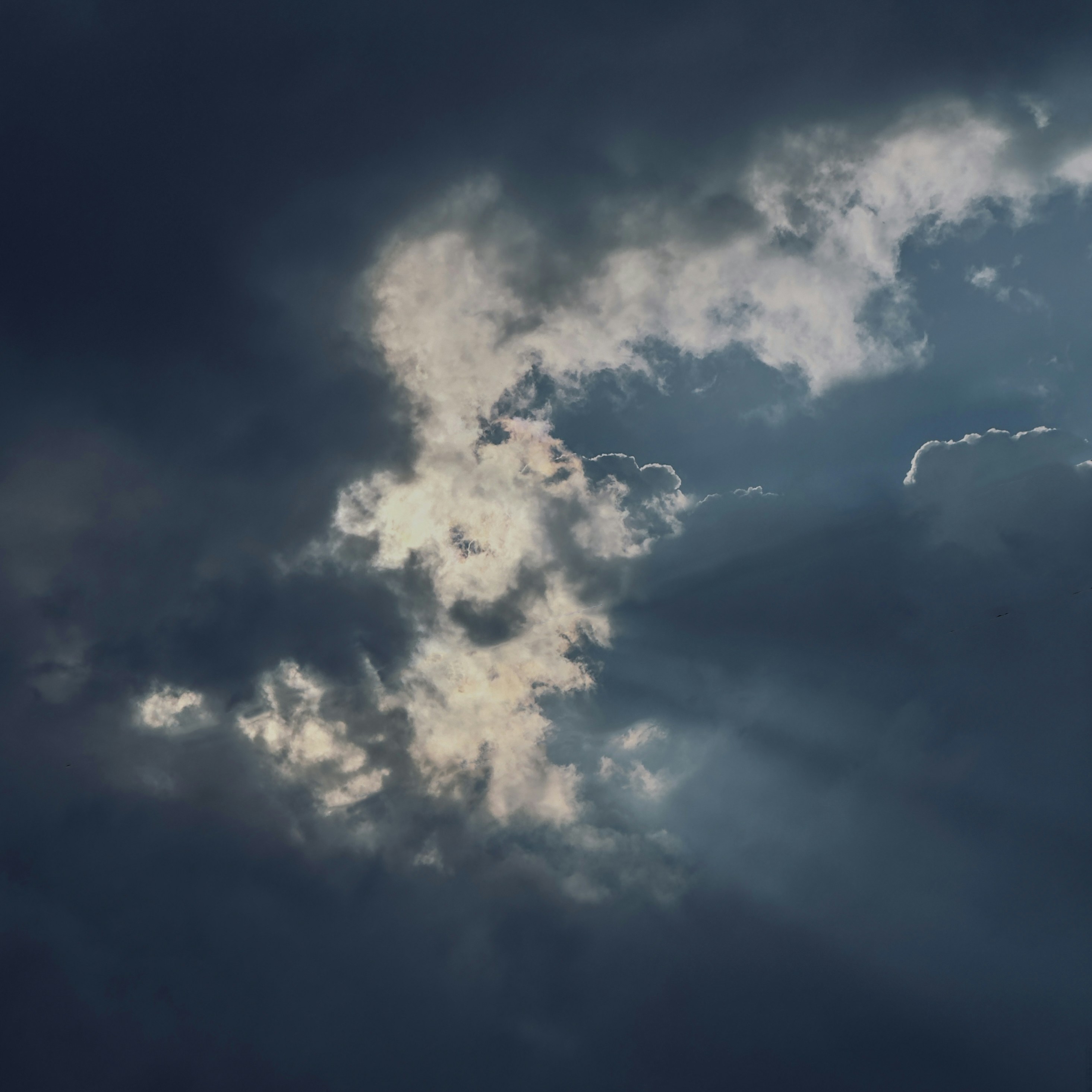 um avião voando através de um céu azul nublado