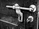 Technician installing a door lock on a wooden door.