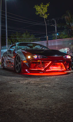 A sleek JDM car with aftermarket parts parked on a city street at dusk, showcasing its enhanced performance.