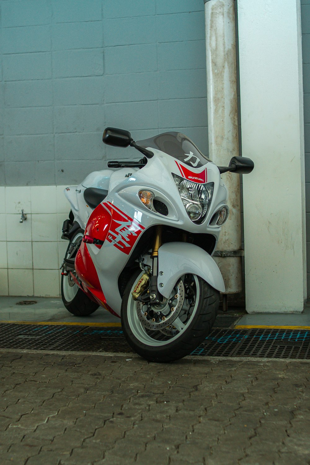 a red and white motorcycle parked in front of a building