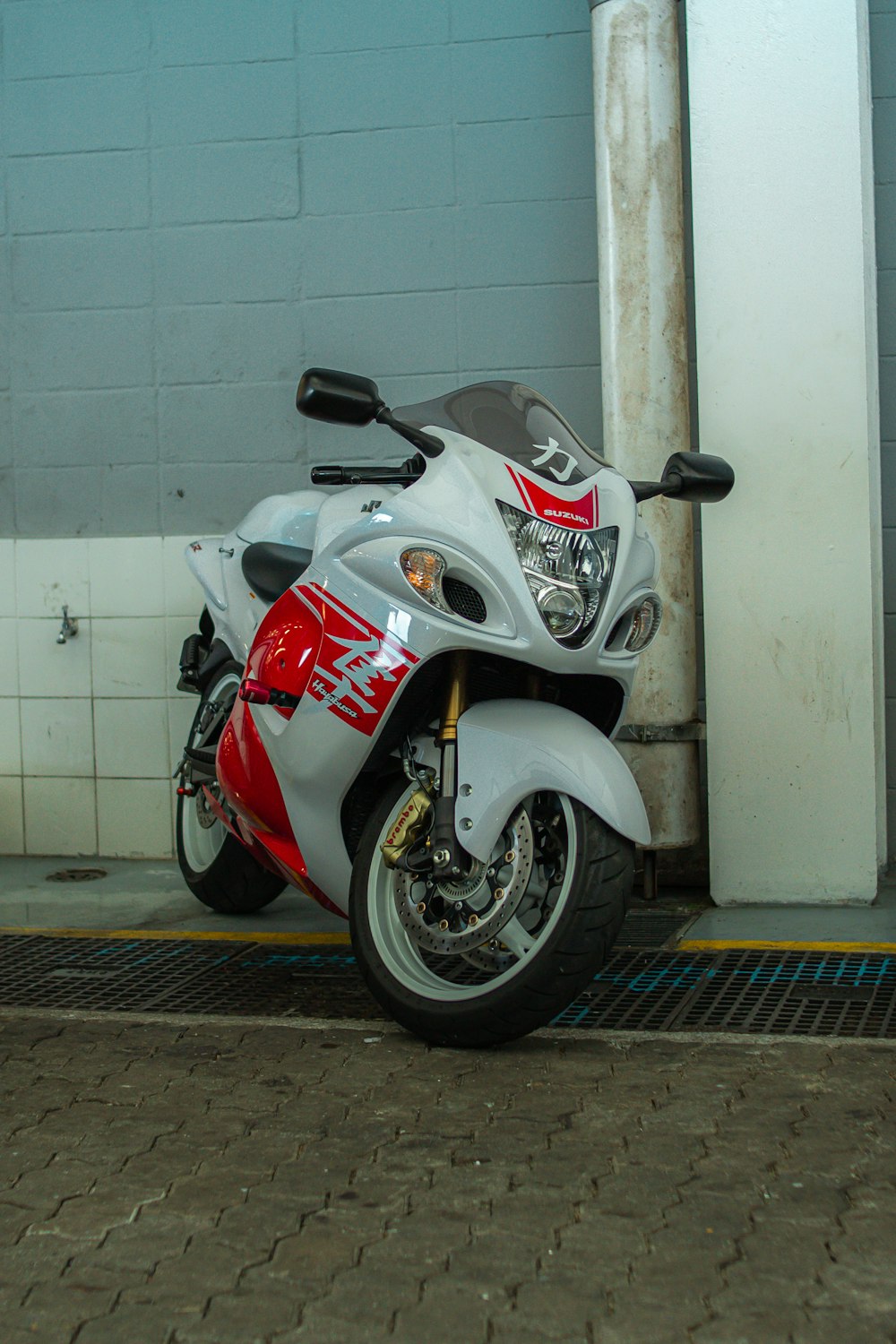 Una motocicleta roja y blanca estacionada frente a un edificio